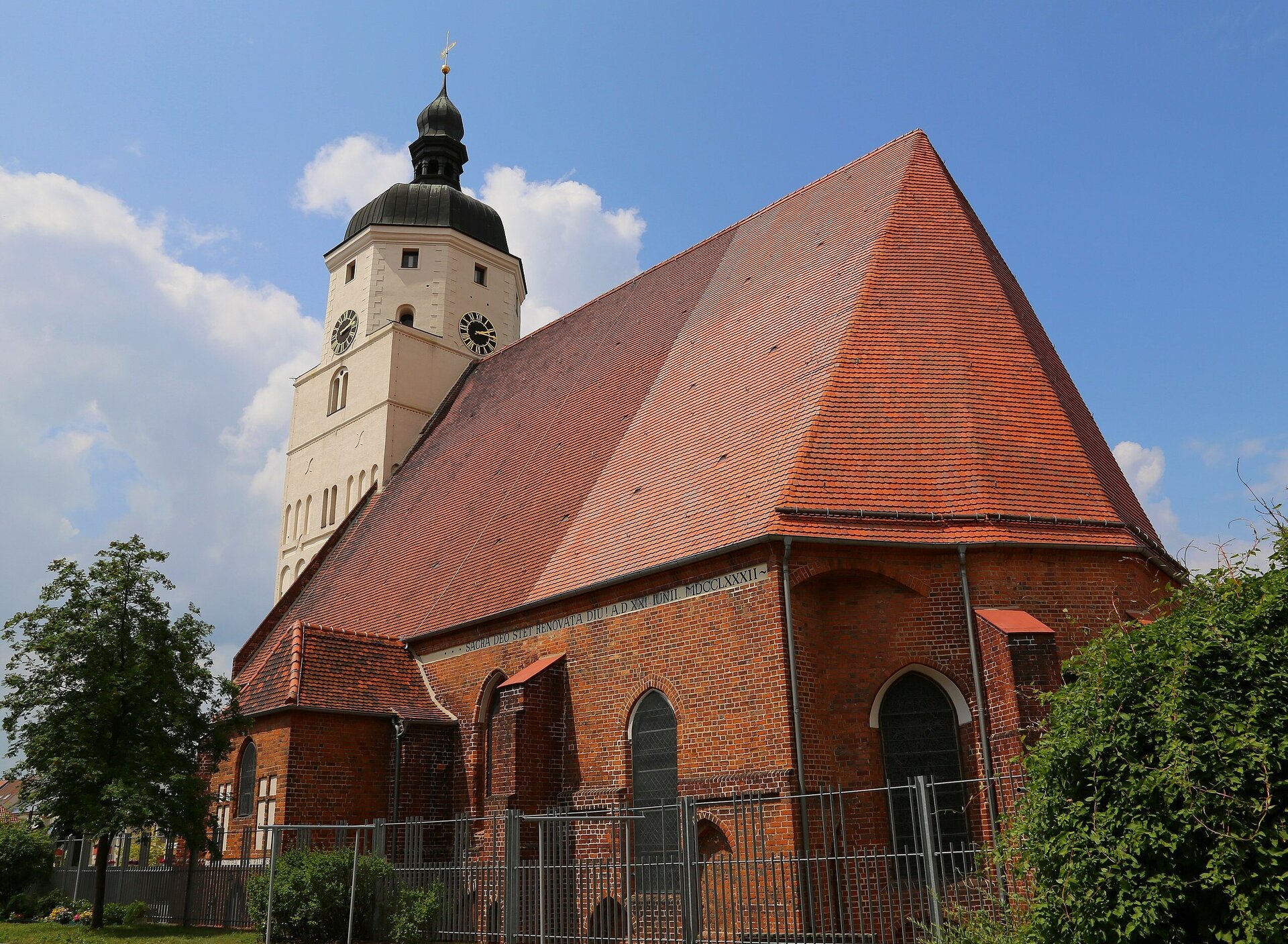 Rote Backsteinkirche mit weißem Turm